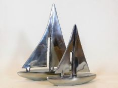 Two stylised polished aluminium yachts