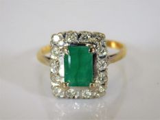 An 18ct gold ring set with emerald & diamonds 4.9g