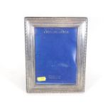 A silver photo frame lacking glass