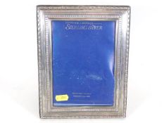 A silver photo frame lacking glass
