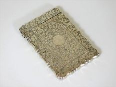 An antique silver card case with chased decor