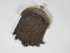 A white metal mesh purse with scroll work clasp