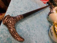 A gents walking cane with decorative white metal h