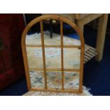 An arched pine framed wall mirror