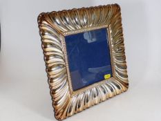 A large silver photo frame with scalloped border