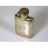A small silver hip flask with initials to front