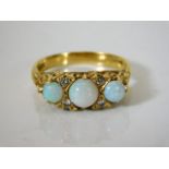 An antique yellow metal ring set with opal & diamo