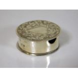 A silver pill box with chased decor in form of hea