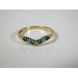 A 9ct gold wishbone style ring set with emerald &