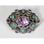 An antique Arts & Crafts silver brooch set with turquoise & amethyst