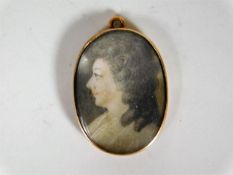 A Georgian yellow metal (tests as gold) pendant set with watercolour on ivory panel
