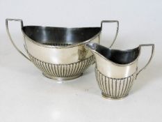A silver sugar bowl with gadrooned sides twinned w