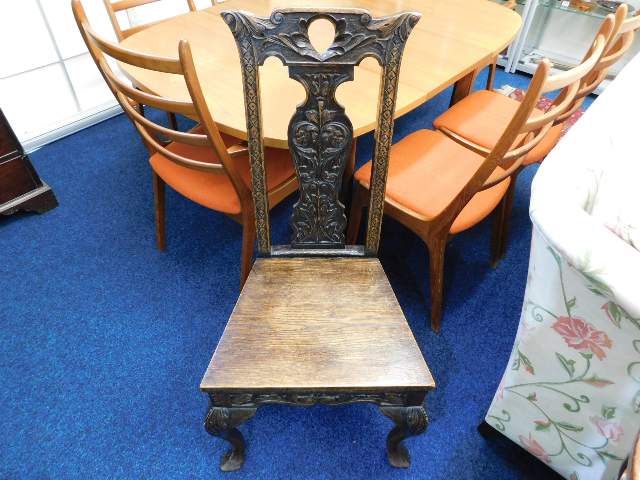 A 1920's Gothic style oak chair with carved splat