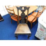 A 1920's Gothic style oak chair with carved splat