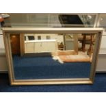 A large bevelled edge wall mirror with decorative
