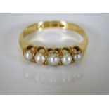 An 18ct gold ring set with five pearls 4.1g