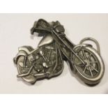 A belt buckle in form of a motorcycle