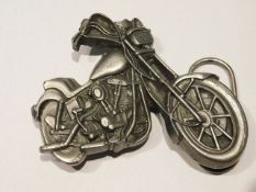 A belt buckle in form of a motorcycle