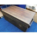 A large flat top wooden trunk with handles either