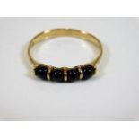 A 9ct gold ring set with round cut sapphires size