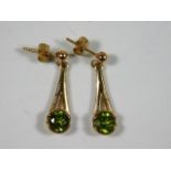 A pair of 9ct gold drop earrings set with peridot