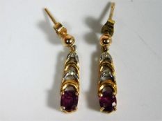 A pair of 9ct gold drop earrings set with ruby & s