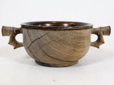 An Oriental hardwood quaich with metal liner