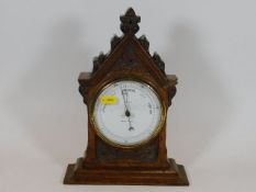 A Gothic style oak mounted barometer