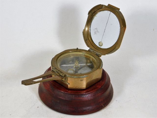 A brass compass with display stand, inscribed S.L.