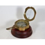 A brass compass with display stand, inscribed S.L.