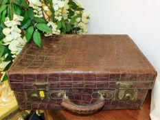 An antique crocodile skin suitcase