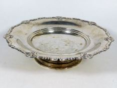 A silver footed bowl with scrollwork decor to edge