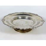 A silver footed bowl with scrollwork decor to edge