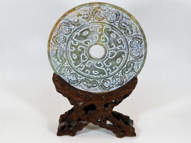 A Chinese soapstone carved disc mounted on natural