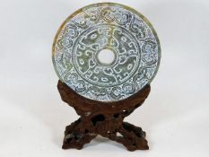 A Chinese soapstone carved disc mounted on natural