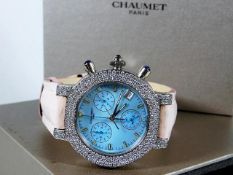 An 18ct gold unisex 42mm Chaumet Paris watch set with diamonds against a powder blue mother of pearl