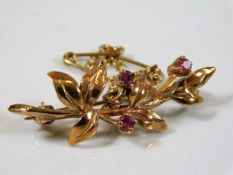 A 9ct rose gold brooch set with three rubies 2.9g