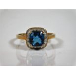 A 9ct gold ring with centre blue stone set with sm