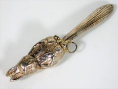 A white metal baby rattle with rabbit decor, some
