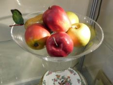 A modern crystal bowl with fake fruit