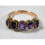 A 9ct gold ring set with five amethyst stones 2.7g