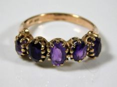 A 9ct gold ring set with five amethyst stones 2.7g