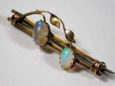 A yellow metal bar brooch set with two opals 3.9g