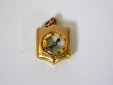 A small 9ct gold compass pendant, glass cracked to