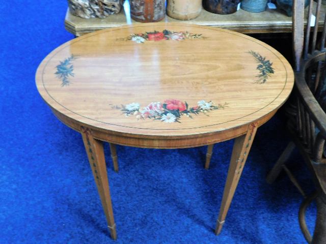 A Regency style satinwood oval hall table with decorative motifs