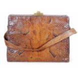 An early 20thC. snakeskin bag with brass fittings