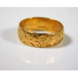 A 22ct wedding band with engraved decor, some wear