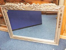 A modern mirror with decorative silver coloured fr