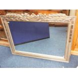 A modern mirror with decorative silver coloured fr