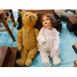 A vintage teddy bear with doll